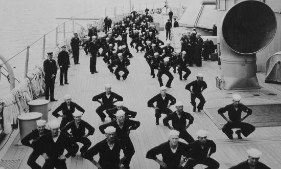 Photograph of sailors undergoing physical fitness training on deck of a ship, date and location unknown.
